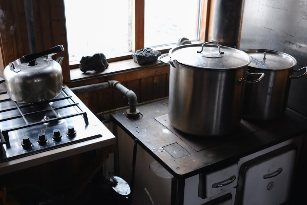 How to Install a Gas Cooktop: pans, pots, and kettles on top of a metal cooktop.