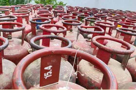 Types of gas fittings: rows of red gas cylinders in an outdoor warehouse.