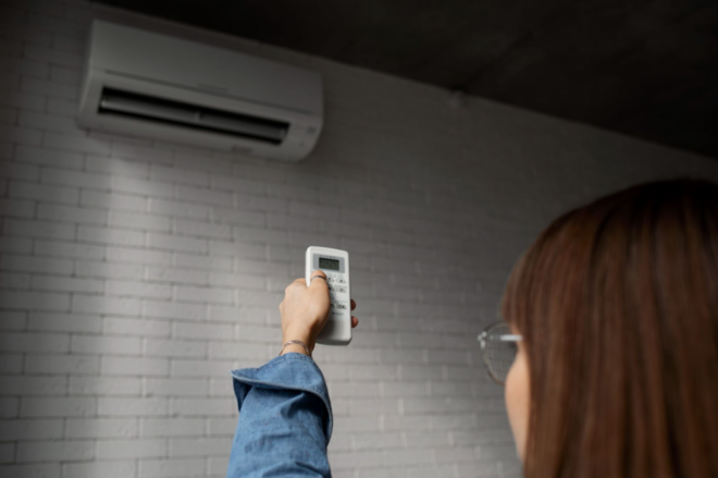 How to relight your pilot light gas heater safely: a young woman turning on the AC