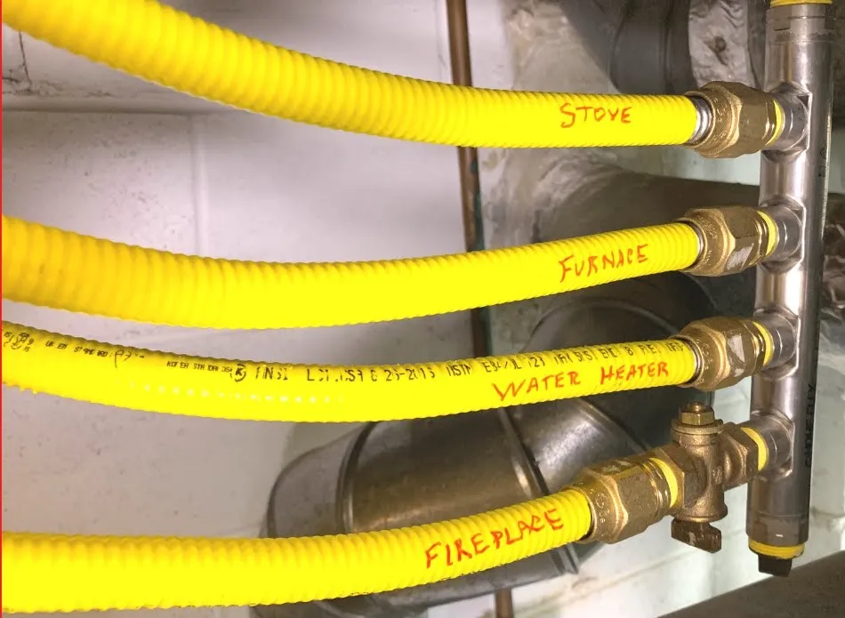 Gas lines split to supply the stove, furnace, water heater, and fireplace. The pipes are clearly labeled in yellow