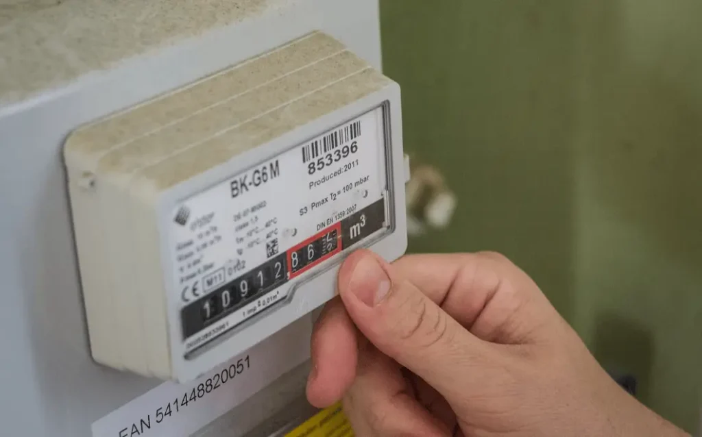 hand-reading-gas-meter-display